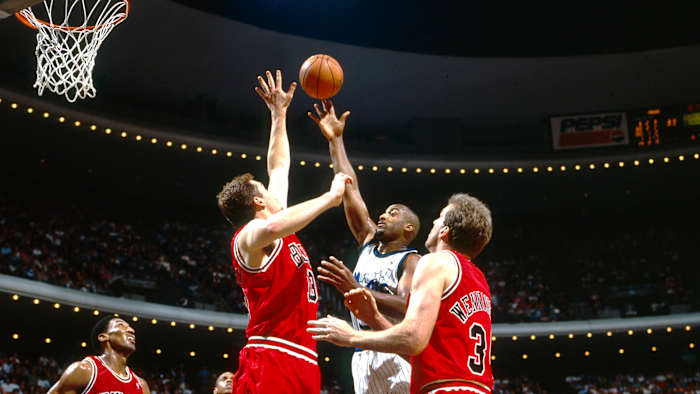 Orlando Magic guard Dennis Scott (3) shoots over Chicago Bulls center Luc Longley (13), Bill Wennington (34) and Scottie Pippen (33) at the Orlando Arena.